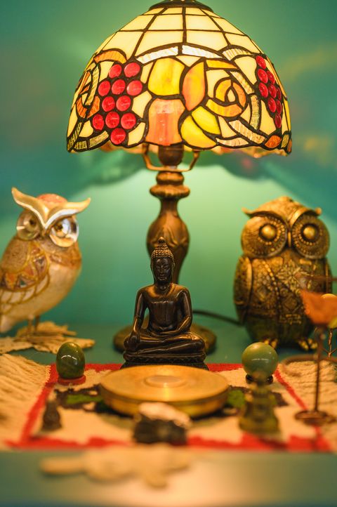 Lampa od obojenog stakla između dve figure sove, na zelenoj pozadini